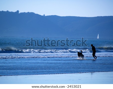 Man runs with his dog at the beach.