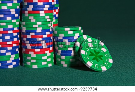 Plastic chips on a green gaming cloth with a shamrock depicting Irish Luck.