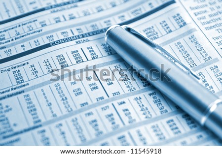 A gold and silver pen placed on a listing of stocks. Shallow depth of field. Perfect for business concepts.