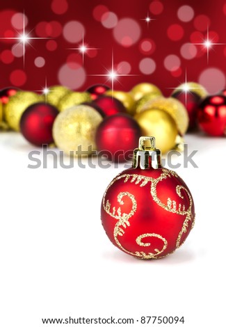 Red and gold Christmas baubles with stars and out of focus baubles in the background
