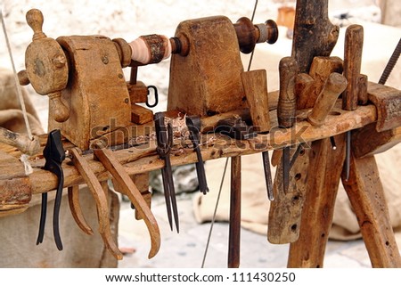 An old lathe with a set of tools for woodworking: hammer, chisels, pliers