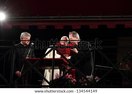 ROME - March 29: The Pope Francis chairs the Way of the Cross on Good Friday under the canopy set up in Colosseum Square on March 29, 2013 in Rome. Personal assistants help with microphone and script.