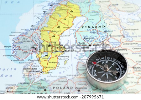 Compass on a map pointing at Norway Sweden and Finland, planning a travel destination in Scandinavia