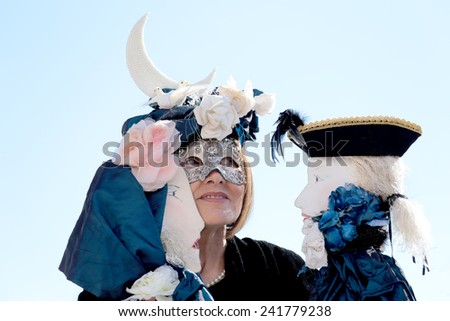 VENICE, ITALY - February 23: An unidentified masked woman plays her two puppets during the traditional festival of Carnival on February 23, 2014 in Venice, Italy
