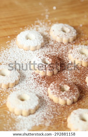 Italian canestrelli biscuits sprinkled with powdered sugar and cocoa. Vertical image
