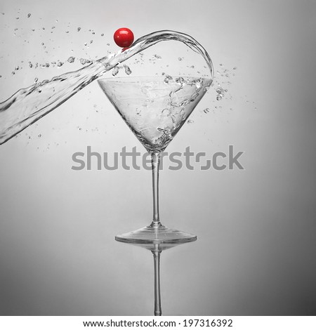 Martini glass with splashes of water and cherries