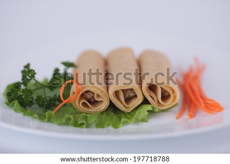 Pancakes with meat with parsley, carrots and lettuce on a white plate
