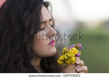 Beautiful young lady, eyes wide shot and smelling fresh spring flowers