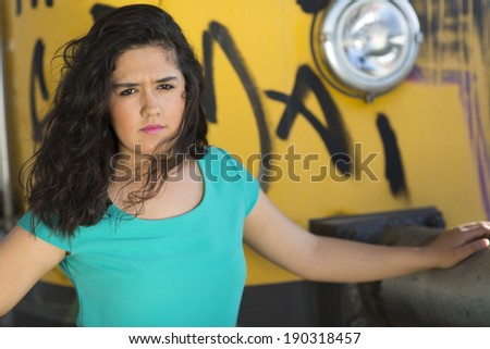 Beautiful young lady standing in the train station and holding the old yellow train