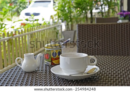 White coffee set on the table at an outdoor cafe on a summer day