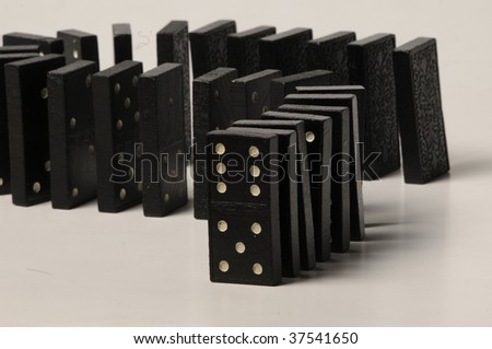 line of black dominoes ready to fall