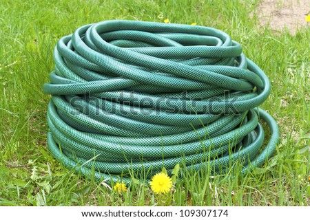 Garden hose for water on the green grass