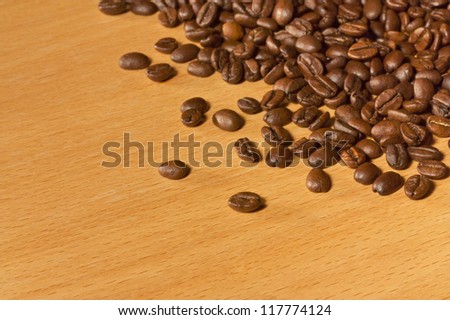 A lot of roasted coffee beans on a wooden table