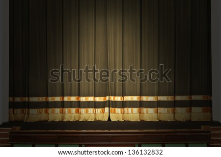 The curtain on the stage in the theater with the lights off