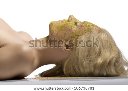 blonde girl with face powder on all skin of the face, she is turned at right and her eyes are closed