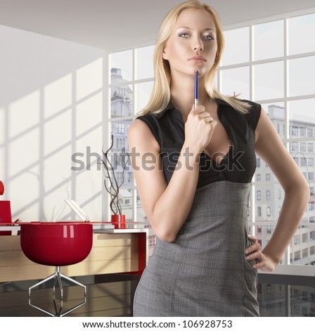 pretty business woman with elegant dress and pen, she is in front of the camera, takes the pen with right hand near the chin and looks in to the lens with serious expression