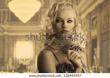 pretty blonde girl with curly hair takes one silver mask, she is turned of three quarters at left, looks at right and takes the mask with right hand