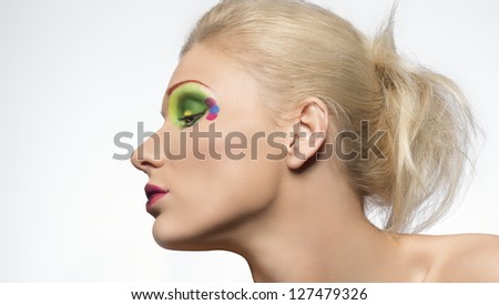 blond girl with creative color make up with her face turned on one side