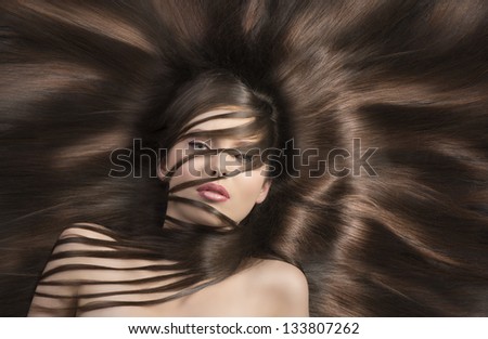 young and very nice woman  with long  hair laying down and some locks on the face and the neck