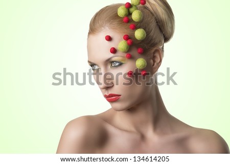 blonde girl with red and green balls on the face