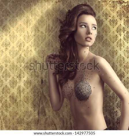 sexy naked lady with modern hair-style and bright make-up. Small piece of mirror on visage and breast.vintage color wallpaper