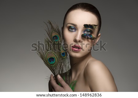 Splendid Naked Brunette Woman With Make Up And Accessory With Colored Peacock Feathers Looking