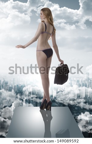 portrait of splendid woman with blonde long hair,  bikini and heels in balance on trampoline taking business bag in the hand between the clouds