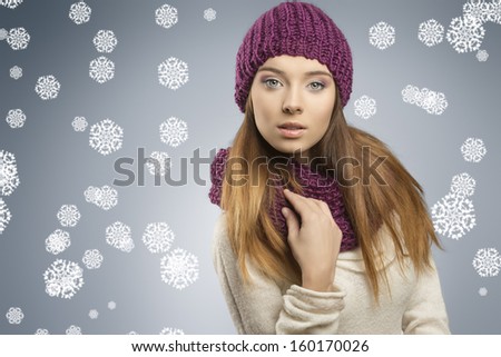 attractive young girl with fashion winter style and long smooth hair. She wearing wool purple hat, scarf and white sweater, looking in camera