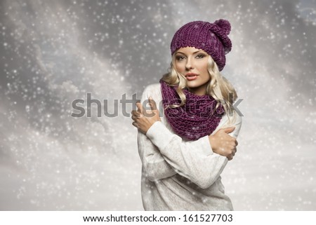 young and sexy blond girl wearing purple scarf and hat in winter dress over white