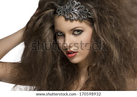 close-up of sensual brunette woman with voluminous curly hair-style, glitter accessory in the hair and strong make-up