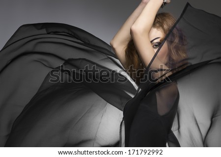 crazy fashion portrait of cute girl with strong gothic bizarre make-up and style, posing with big flying veil skirt