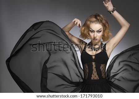 fashion portrait of pretty girl with bizarre gothic style, make-up and accessories and big flying skirt. Carnival look