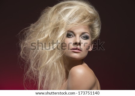 beauty portrait of alluring blonde girl with fashion bushy blonde hair-style, pretty make-up, perfect skin and nude shoulders on red background