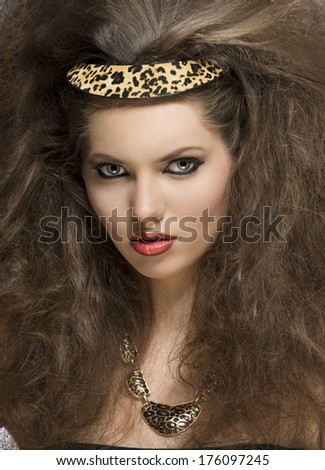fashion woman posing in close-up portrait with wild style, curly hair-style, leopard accessory and strong make-up