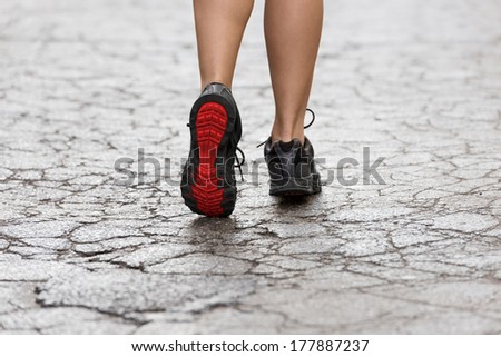 back shot of young lady with fitness shoes in act to walking ,running on a broken fashion road. USED SHOES