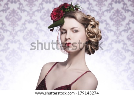 close-up portrait of sexy fashion blonde girl posing with elegant romantic hair-style with red roses, red sexy dress and heart shaped lipstick