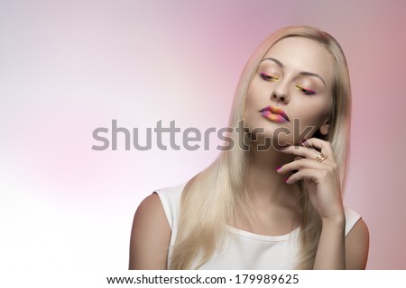 attractive blonde female posing with multicolor make-up, cute silky smooth hair and white dress