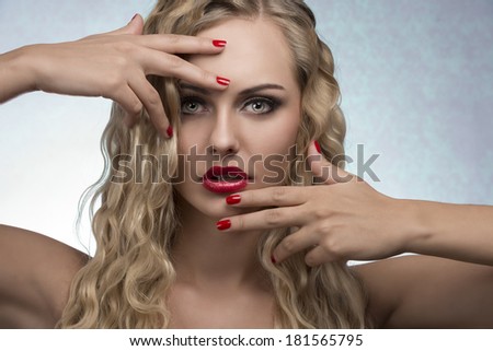 beauty portrait of sexy female with luxury red lipstick, nail polish and blonde wavy shiny hair-style