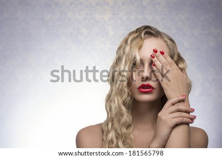 cute blonde female with long wavy hair, red lips and nail polish