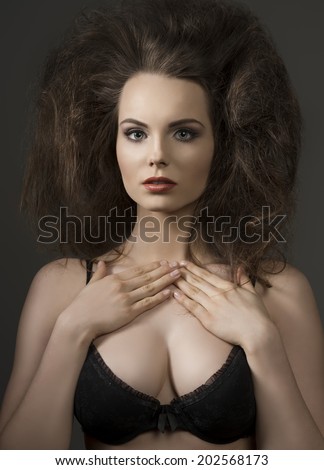 sexy brunette girl posing with black bra and fashionable volume hair-style and red lipstick