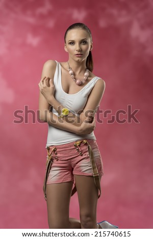 brunette woman in sensual pose with casual modern style wearing sexy shorts, wrist watch and suspenders