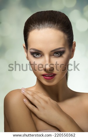 young beautiful woman with hair do with light eyes looking in camera with half smart smile .