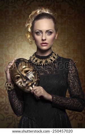 carnival portrait of blonde woman with aristocratic antique lady mask, elegant lace dress and baroque jewellery. Venetian mask in the hand