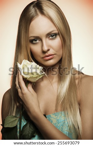 dress, long hair and white rose in the hand \close-up shoot of pretty blonde woman with beautiful long hair, wearing spring stylish dress and taking white rose in the hands. Romantic expression