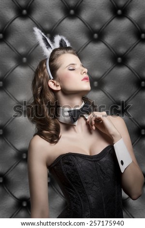 beautiful brunette female in sensual pose in glamour ester shoot with bunny ears, corset and black papillon, wearing like sexy playgirl