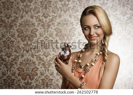 spring blonde woman with long braid hair-style posing with small soft easter bunny toys in close-up portrait