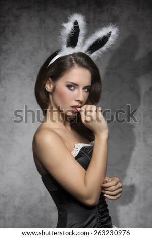 Beautiful, charming, sexy, elegant brunette woman in black corset and fluffy rabbit, easter, ears with nice make up.