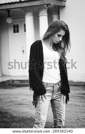 black and white images Cute brunette girl with long natural hair and stylish make-up walking outdoor with trendy casual clothes .HDR toning