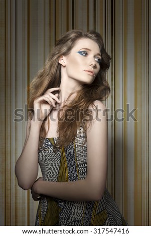fashion shoot of sexy female with long natural hair, cute blue make-up and spring vintage printed dress