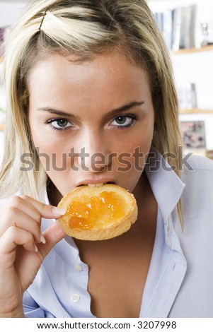 a sensul blond girl eating a toast with jam one morning during her breakfast